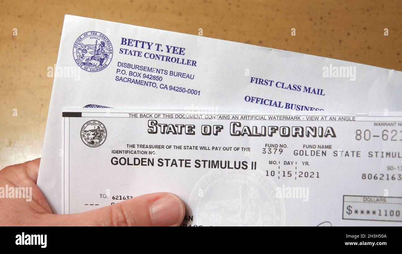 Vista, CA USA - 28 ottobre 2021: Primo piano di mano che tiene un Golden state Stimulus check inviato dallo Stato della California come pagamento diretto a qual Foto Stock
