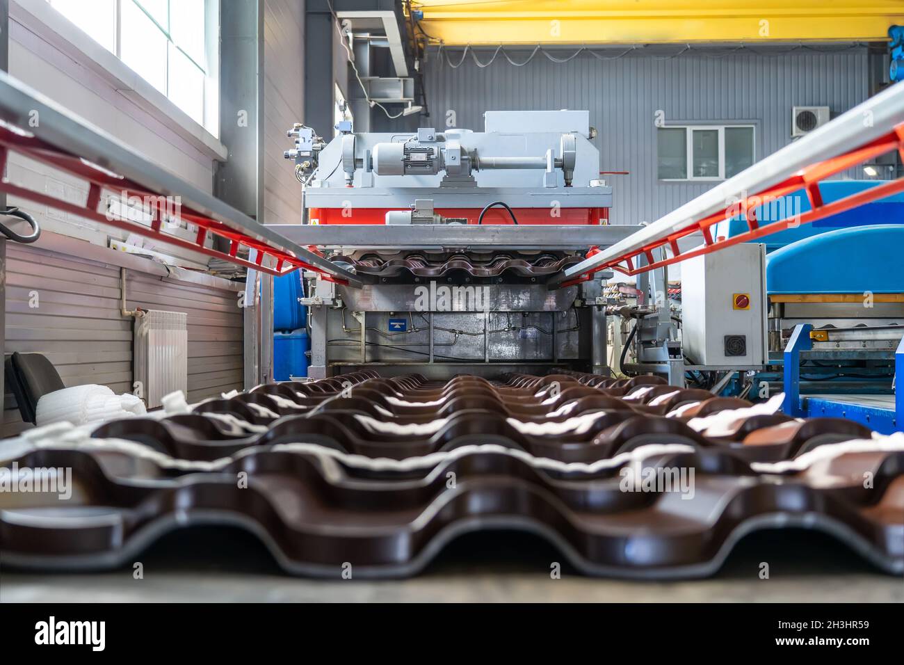 Tegole metalliche in acciaio zincato in lamiera in fabbrica. Foto Stock