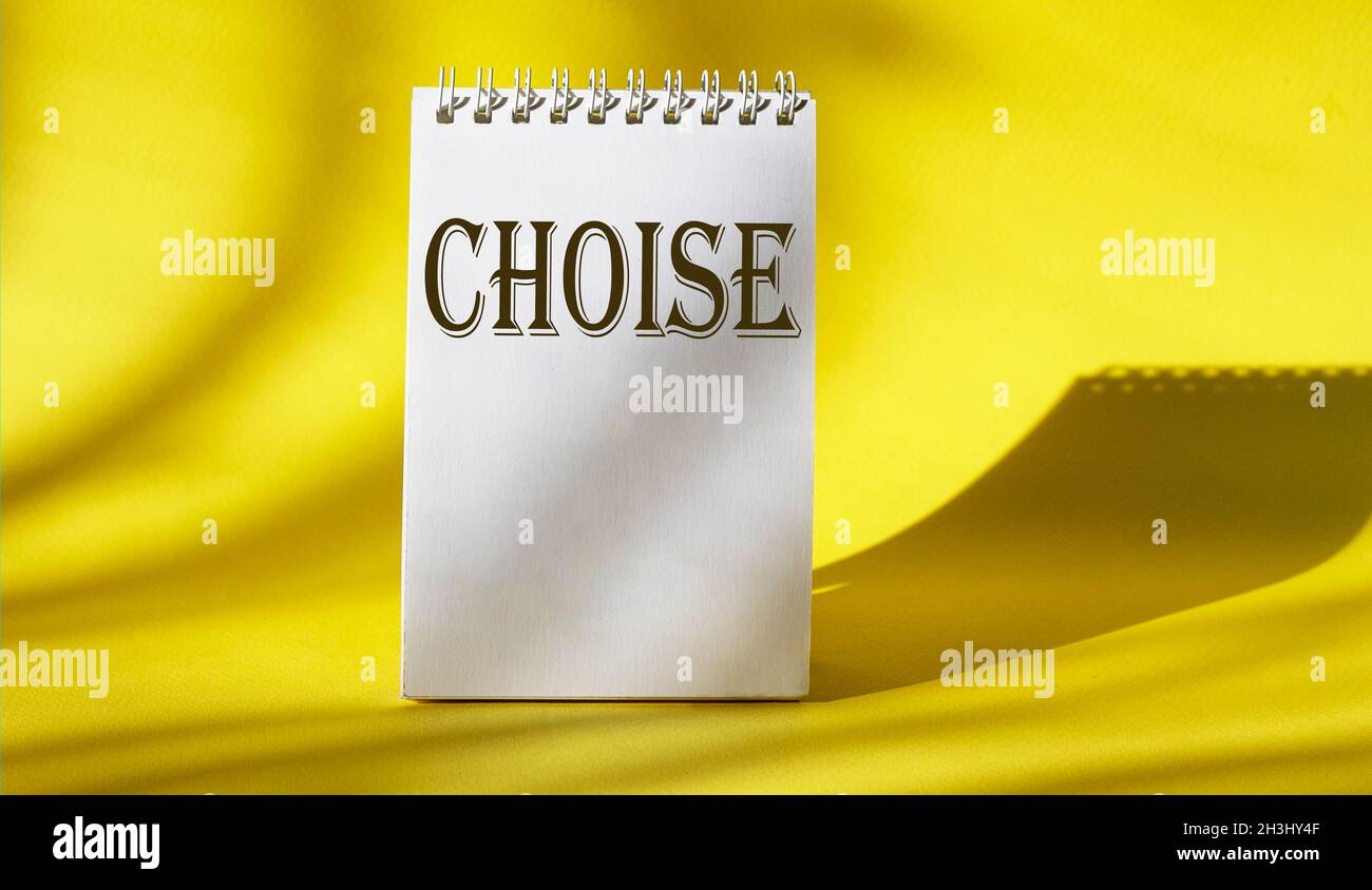 La parola scelta scritta su calendario bianco e sfondo giallo Foto Stock