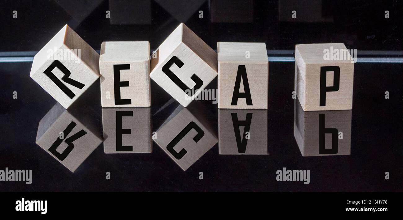 Riepilogo di parole fatto da blocchi di legno su sfondo nero Foto Stock