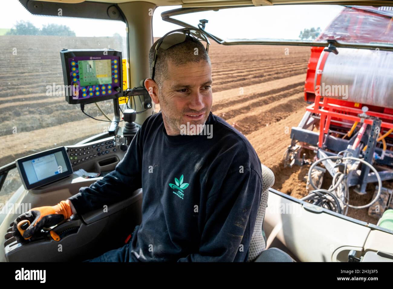 Un membro dello Yad Mordechai kibbutz pianta patate con macchinari moderni nel sud d'Israele Foto Stock