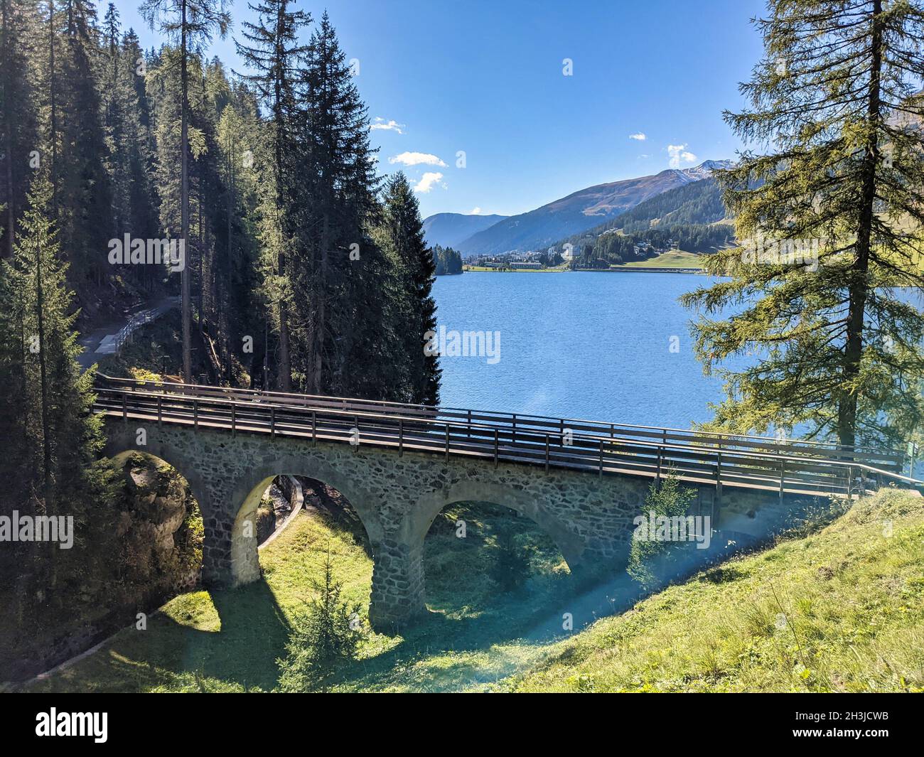 Ponte ferroviario di fronte al lago di davos. Bellissimo viadotto vecchio di fronte al lago di montagna in svizzera.ferrovia pista Foto Stock
