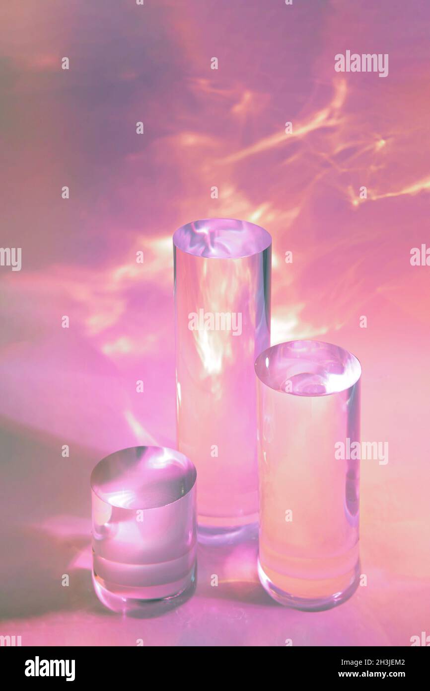 tre podi in vetro chiaro su sfondo rosa pastello Foto Stock