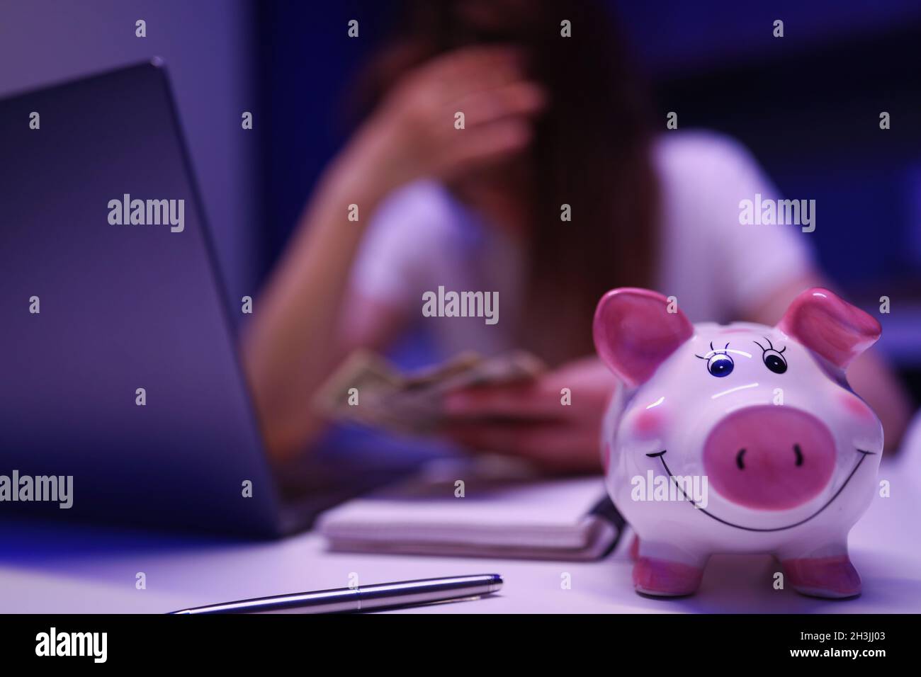 Donna cercare di salvare in su in moneybox Foto Stock