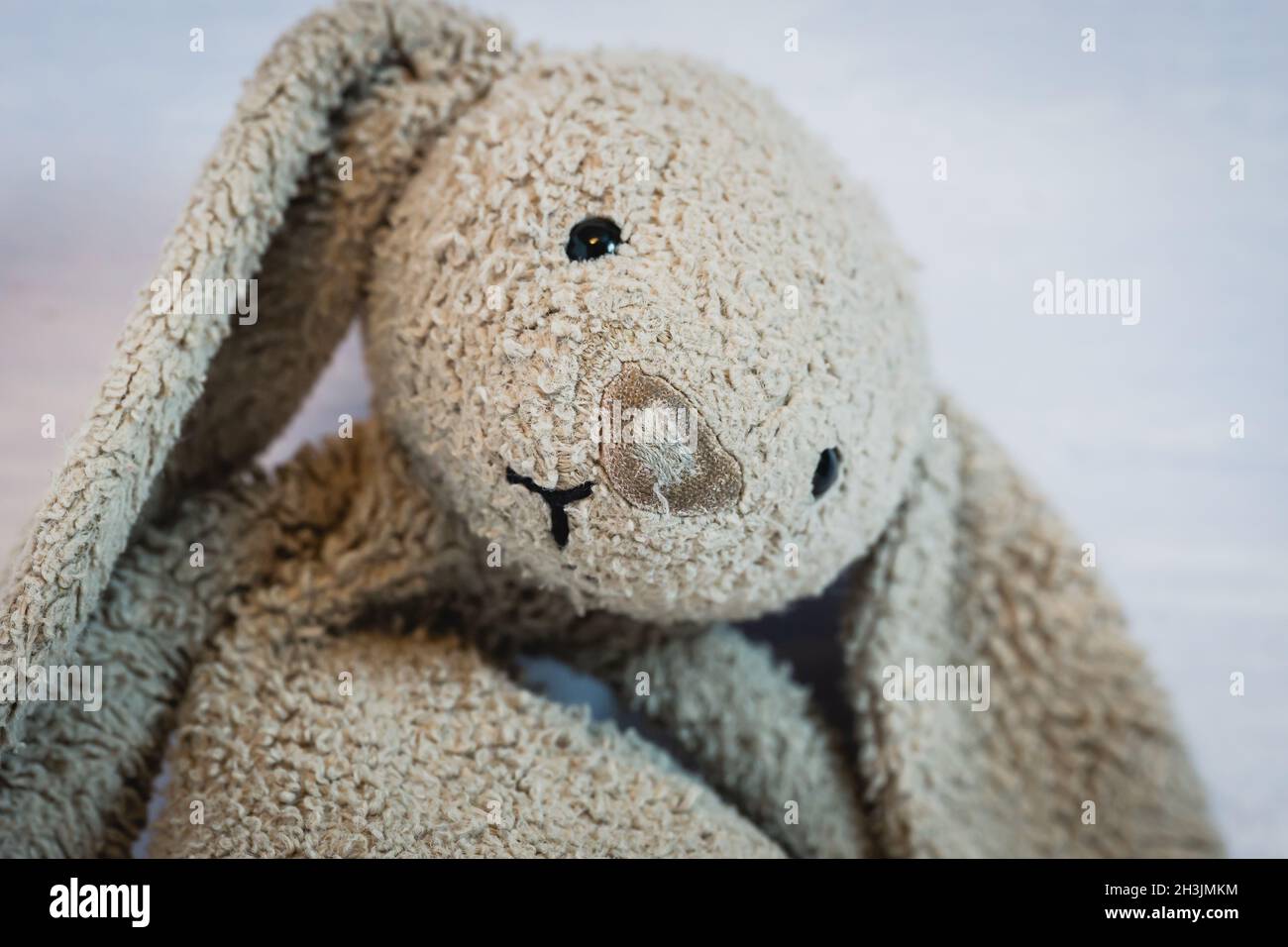 Coniglio giocattolo del bambino con un naso riparato Foto Stock