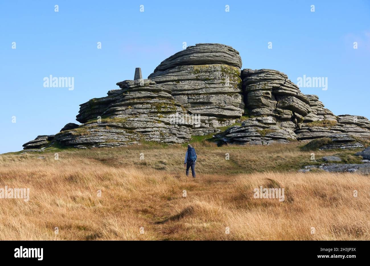 Walker si avvicina a Great Links Tor con il suo punto di trig prominente su Dartmoor occidentale nel Devon Regno Unito Foto Stock