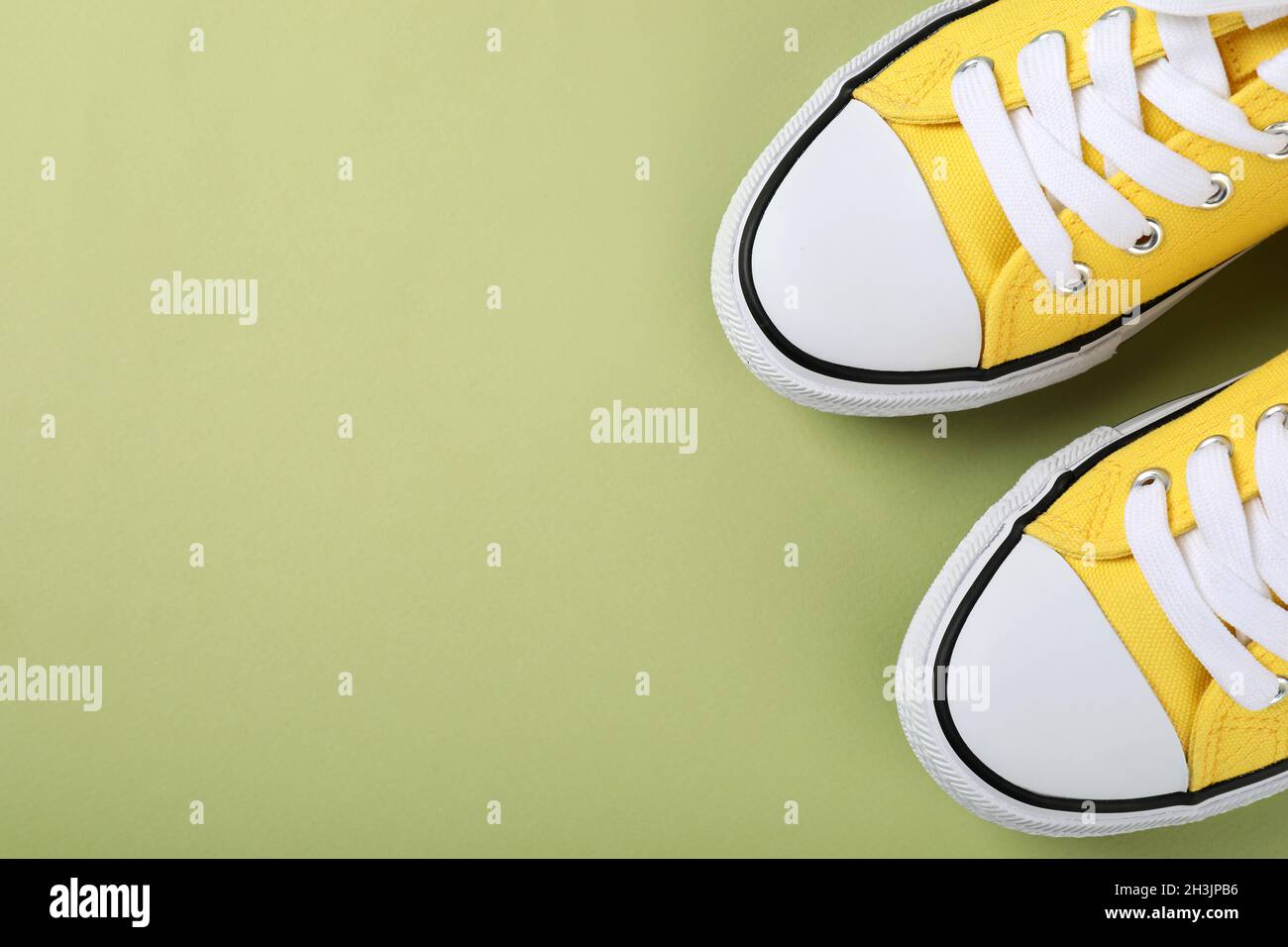 Un paio di sneaker gialle su sfondo verde Foto Stock
