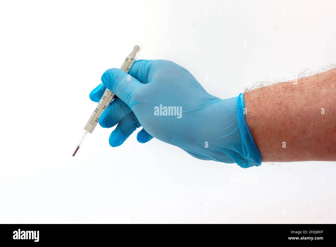Mano dell'uomo in guanto di lattice blu che tiene il termometro medico isolato su sfondo bianco Foto Stock