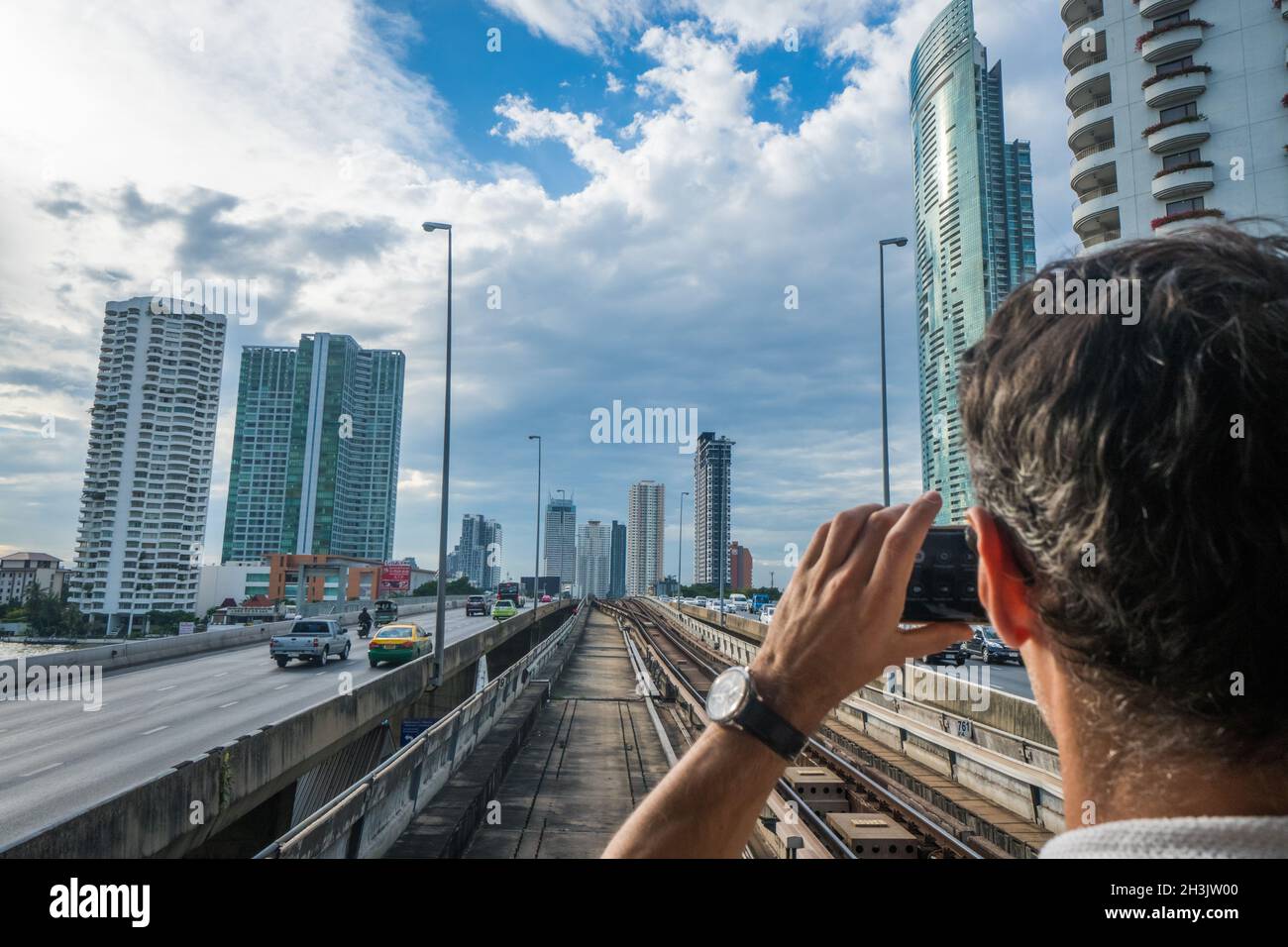 Uomo turistico che utilizza il telefono cellulare per fare foto del panorama di Bangkok Foto Stock