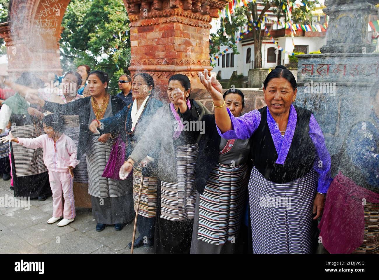 Nepal. Valle di Kathmandu. Swayambunath stupa. Donna tibetana che offre farina per Losar, il nuovo anno tibetano. Foto Stock