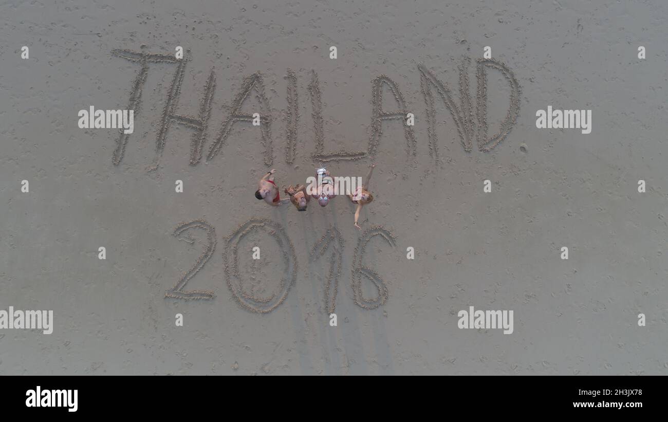 Foto dall'alto di persone in piedi sulla spiaggia tropicale con Thailandia 2016 scritto in sabbia Foto Stock