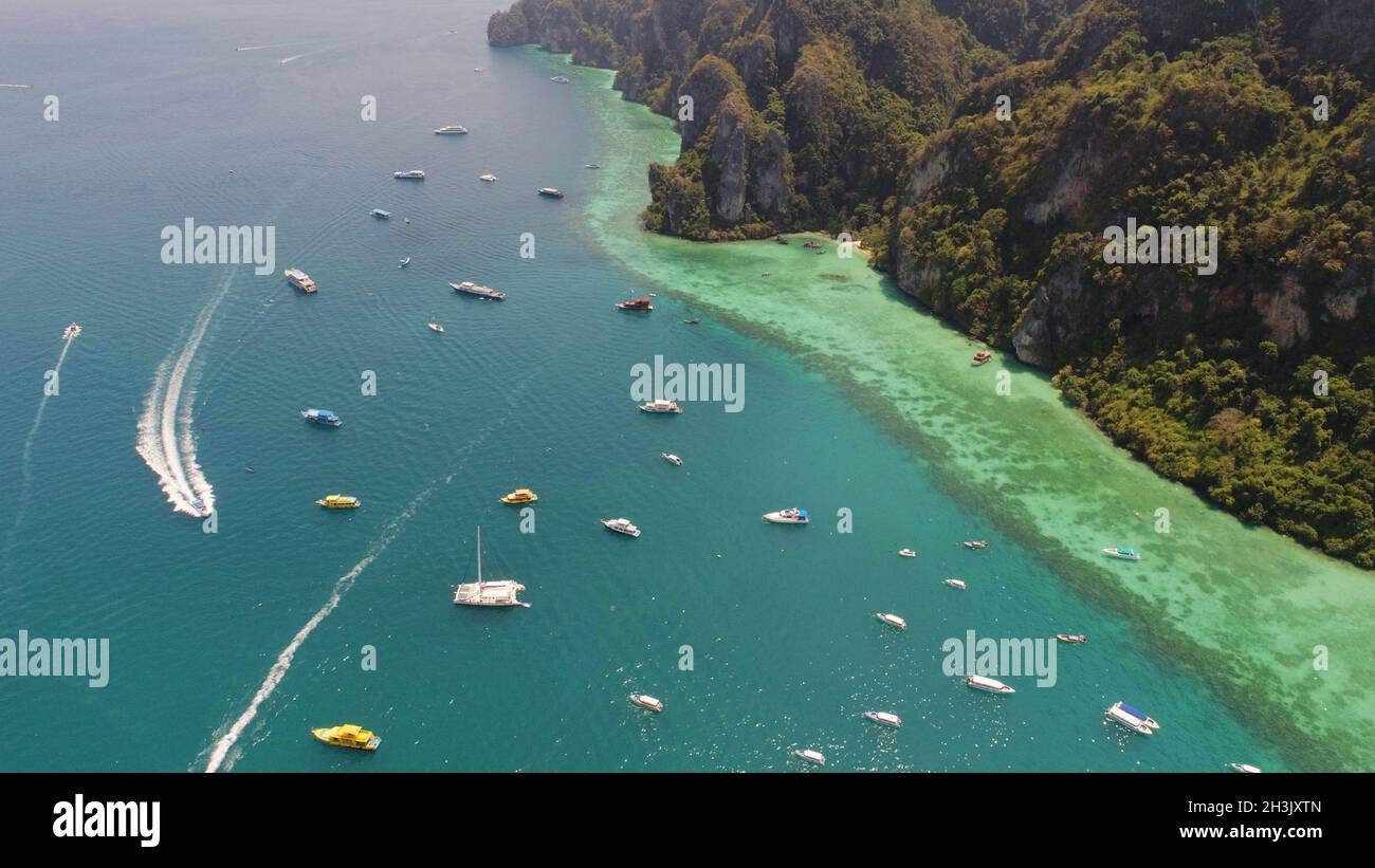 Foto aerea con droni di barche a vela e yacht nella baia dell'iconica isola tropicale di Phi Phi Foto Stock