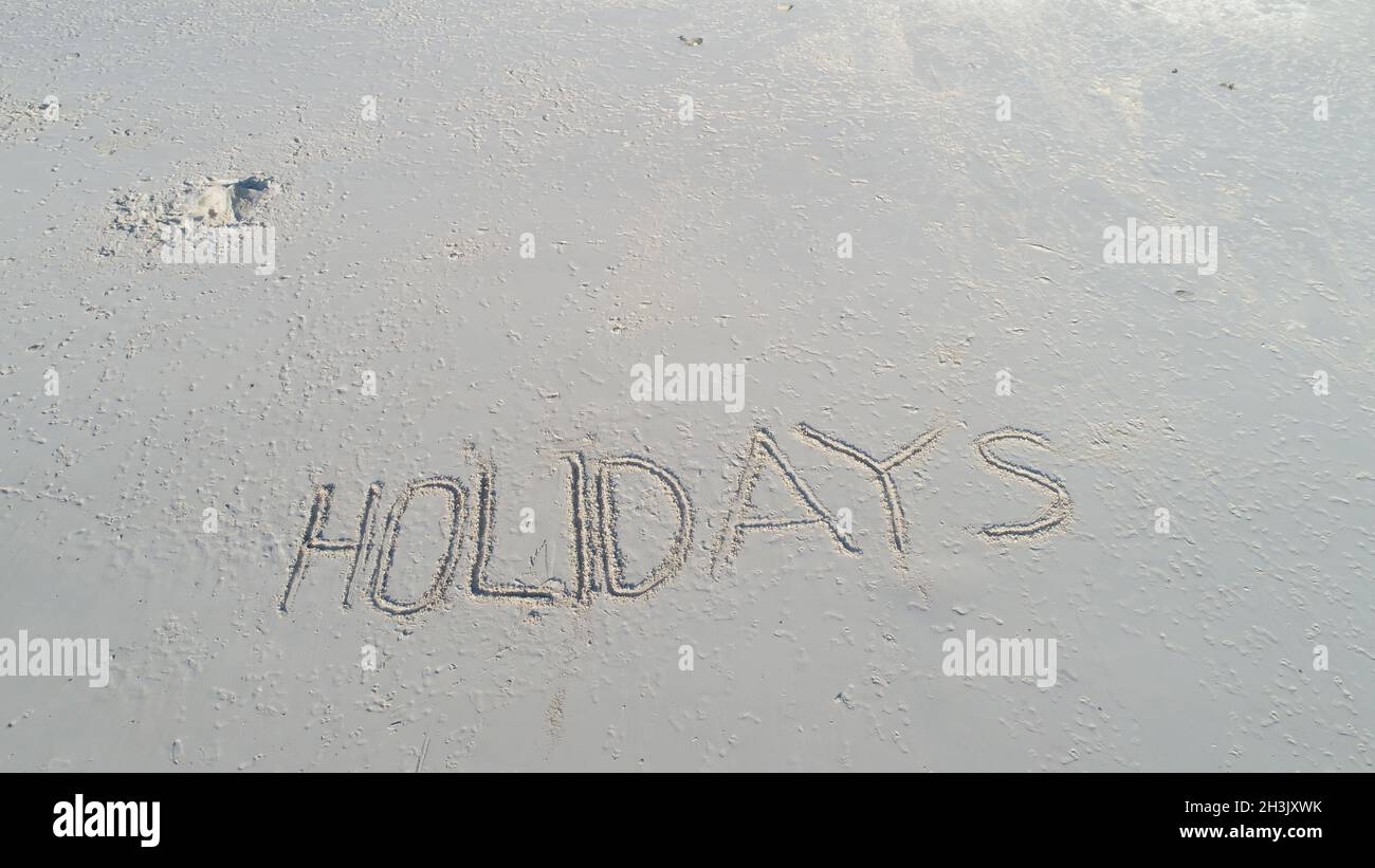 Vacanze scritta nella sabbia sulla spiaggia Foto Stock