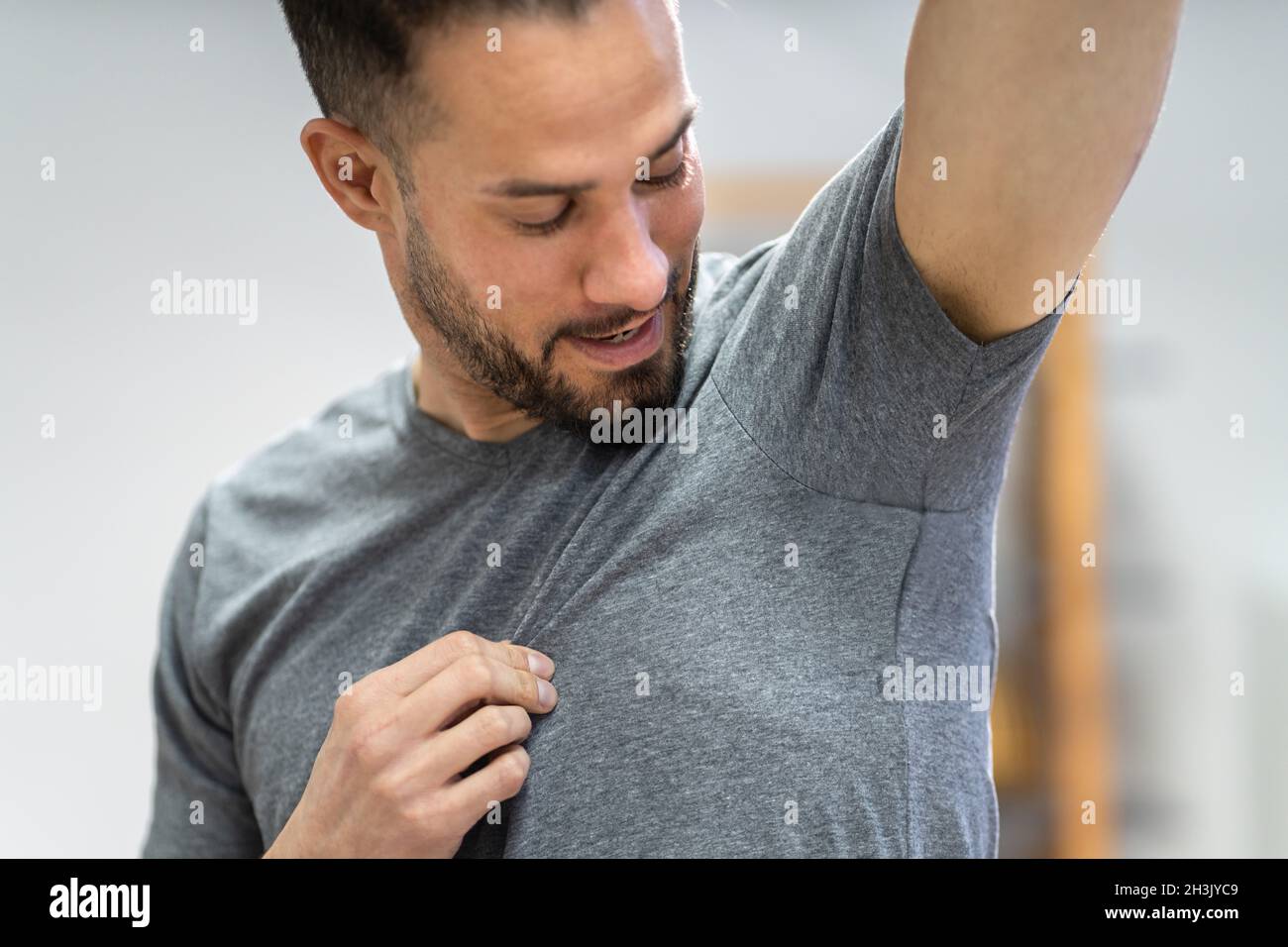 Atleta che usa deodorante antitraspirante contro sudorazione iperidrosi Foto Stock