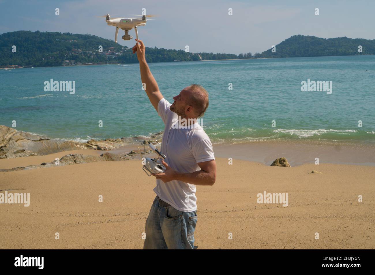 Uomo con drone macchina fotografica sulla spiaggia Foto Stock