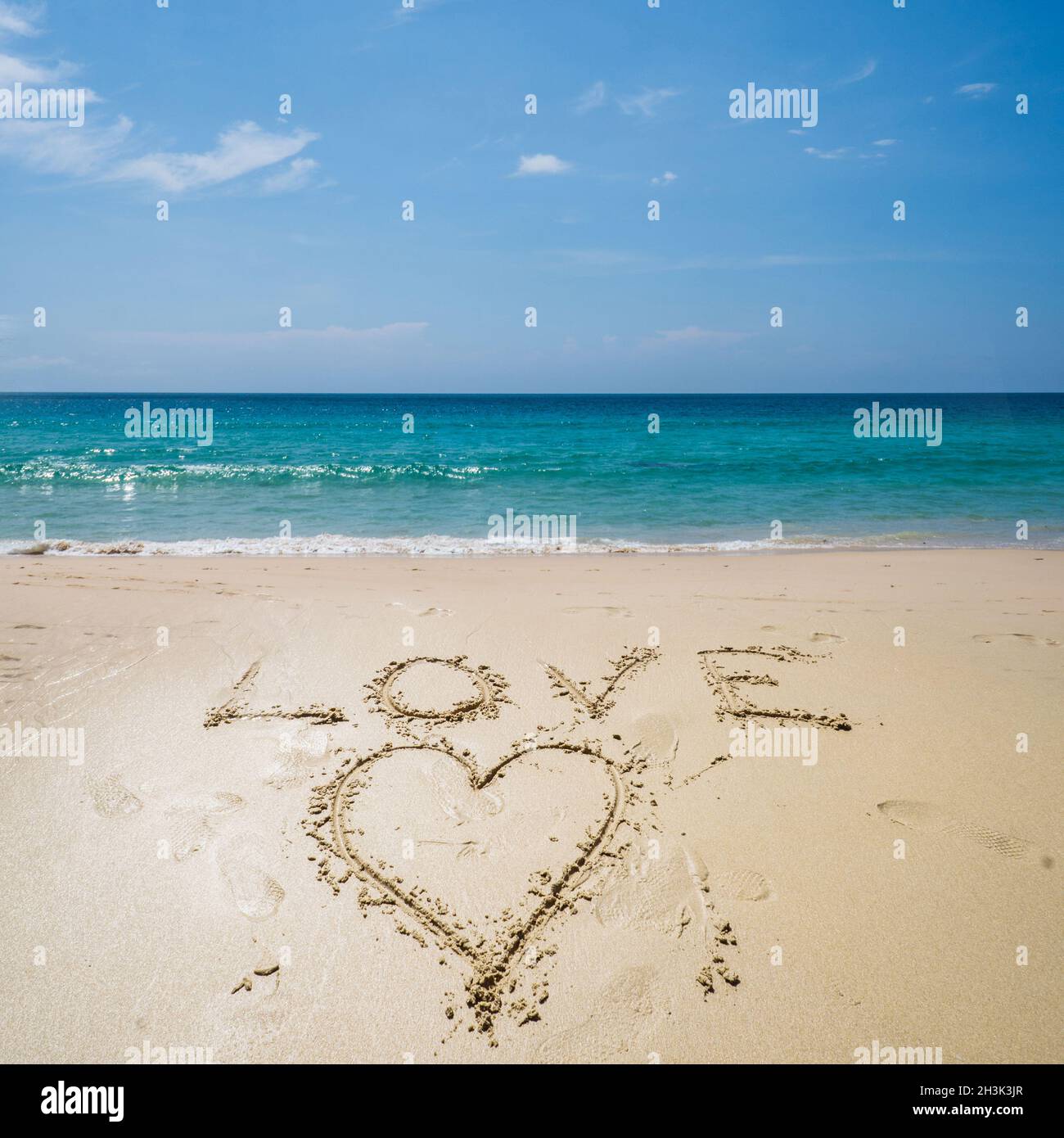 Amore scritto sulla spiaggia sopra il mare Foto Stock