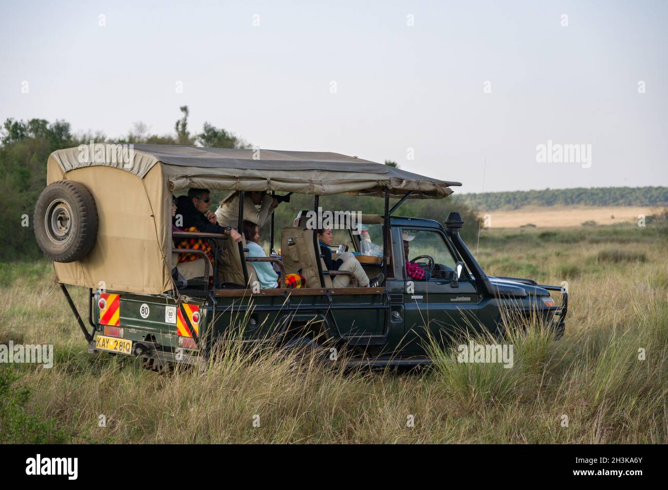 I turisti sedevano in attesa in un 4x4 Toyota Landcruiser aperto, Masai Mara, Kenya Foto Stock