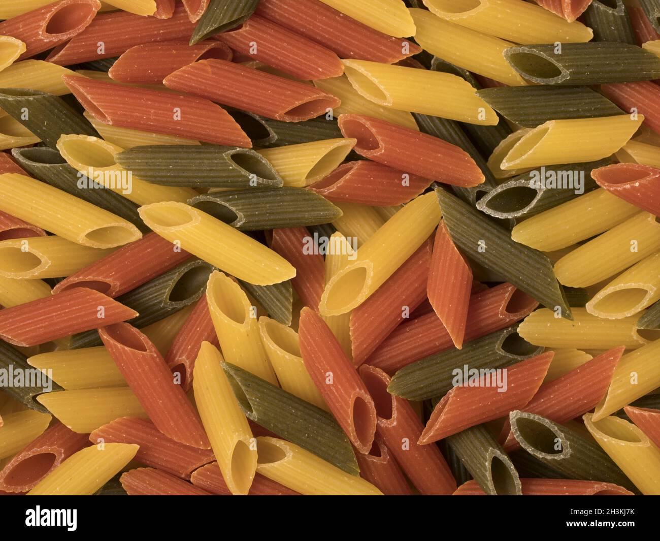 Tri-color penne pasta. Pomodoro, spinaci e pasta di grano. Vista dall'alto. Foto Stock