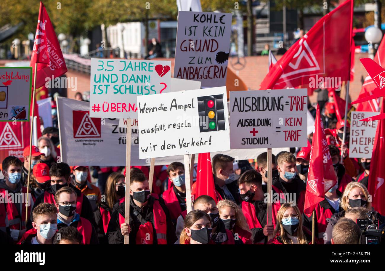 Amburgo, Germania. 29 ottobre 2021. I partecipanti di un rally per la giornata d'azione nazionale di IG Metall sotto il motto 'Fairwandel' (giusto cambiamento) al Sankt Pauli Fischmarkt tenere in mano i cartelli che indicano '3.5 anni e poi è finita?', 'se i semafori falliscono, regoleremo il traffico', "Il carbone non è un motivo per assumere" e "formazione = scala salariale, studi di formazione = nessuna scala salariale". Credit: Daniel Bockwoldt/dpa/Daniel Bockwoldt/dpa/Alamy Live News Foto Stock