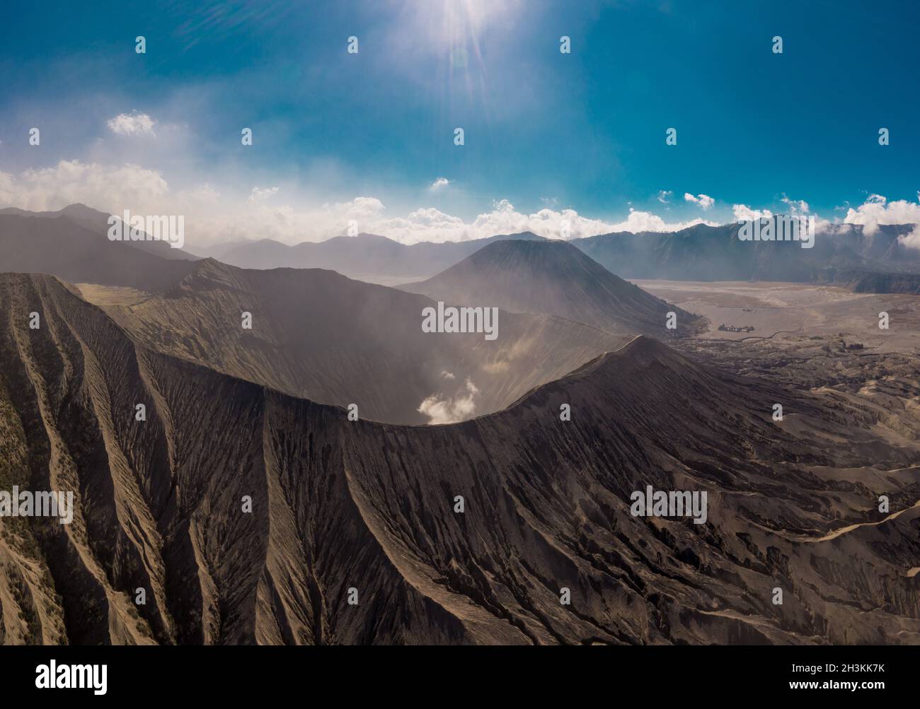 Vista aerea cinematografica del cratere del Monte bromo con fumo attivo del vulcano a Giava Est Foto Stock