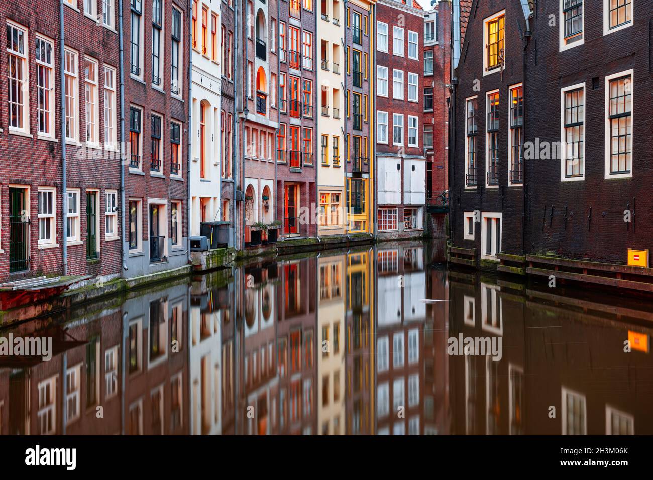 Amsterdam, Paesi Bassi, con stretti canali ed edifici che li fiancheggiano al mattino. Foto Stock