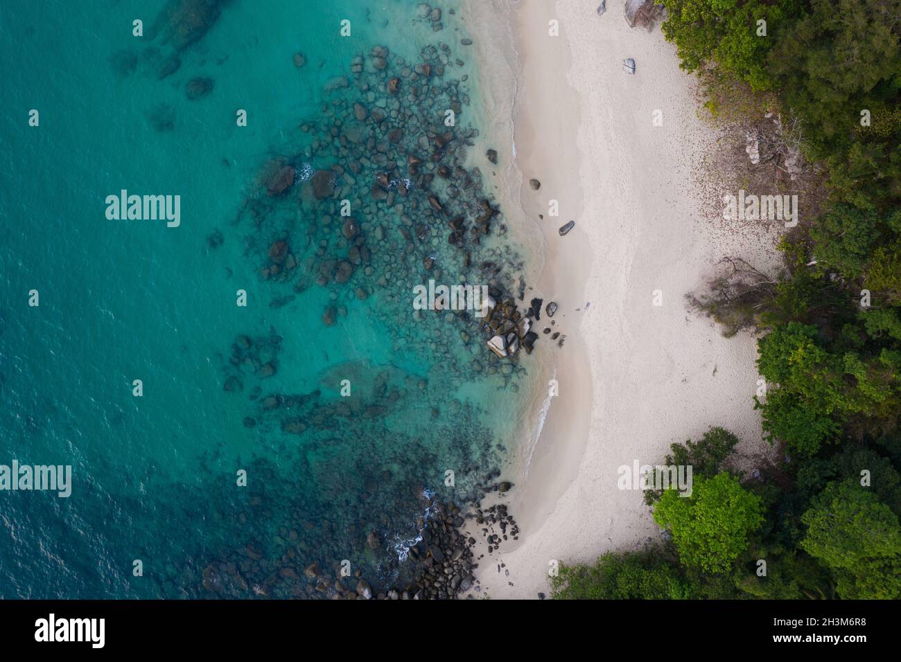 Vista aerea di spiaggia tropicale vuota con acque turchesi del mare e rocce Foto Stock