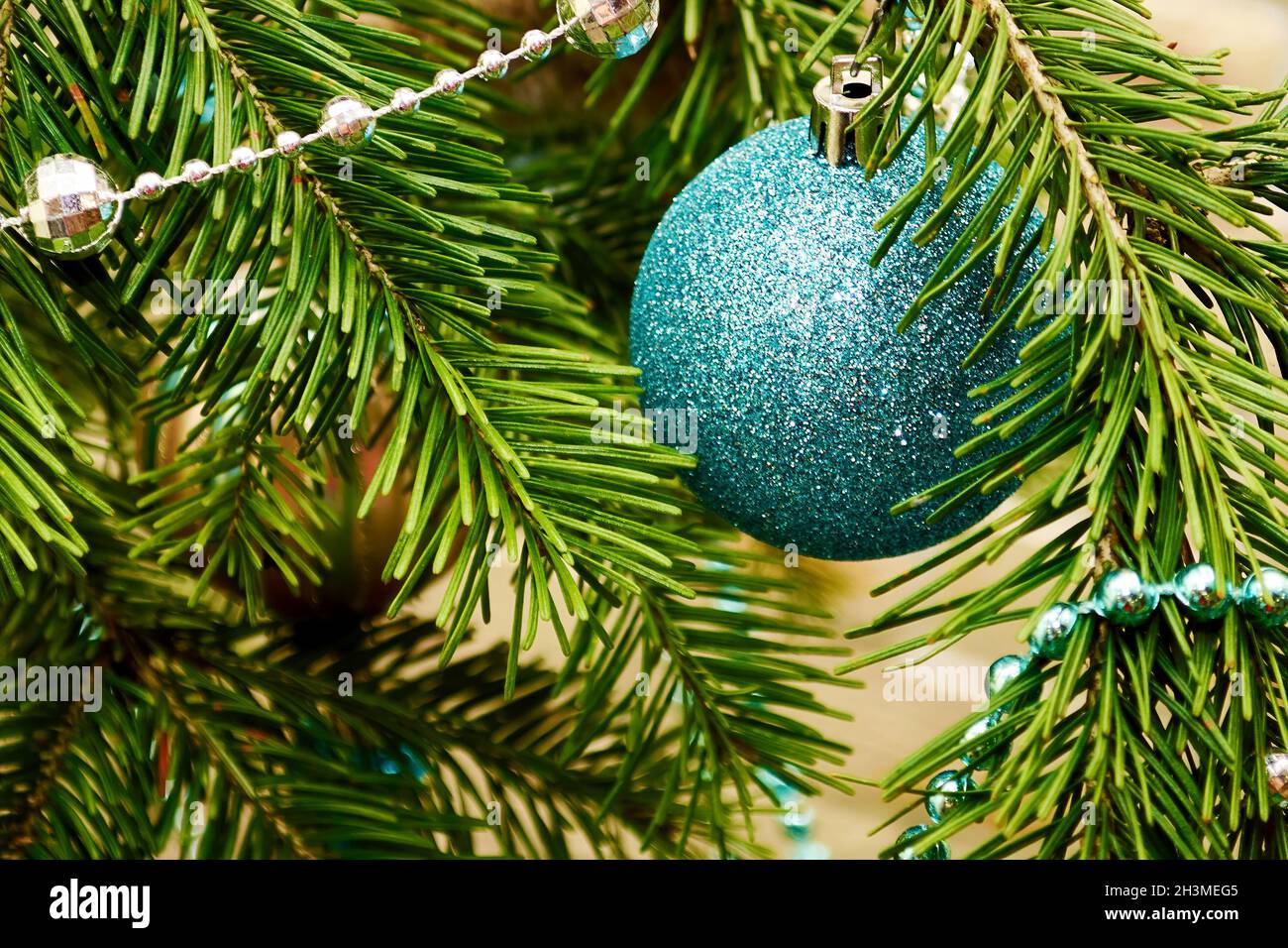 Sfera blu lucido appesa sul ramo sempreverde dell'albero di Natale. Cartoline e sfondi per le vacanze di nuovo anno Foto Stock