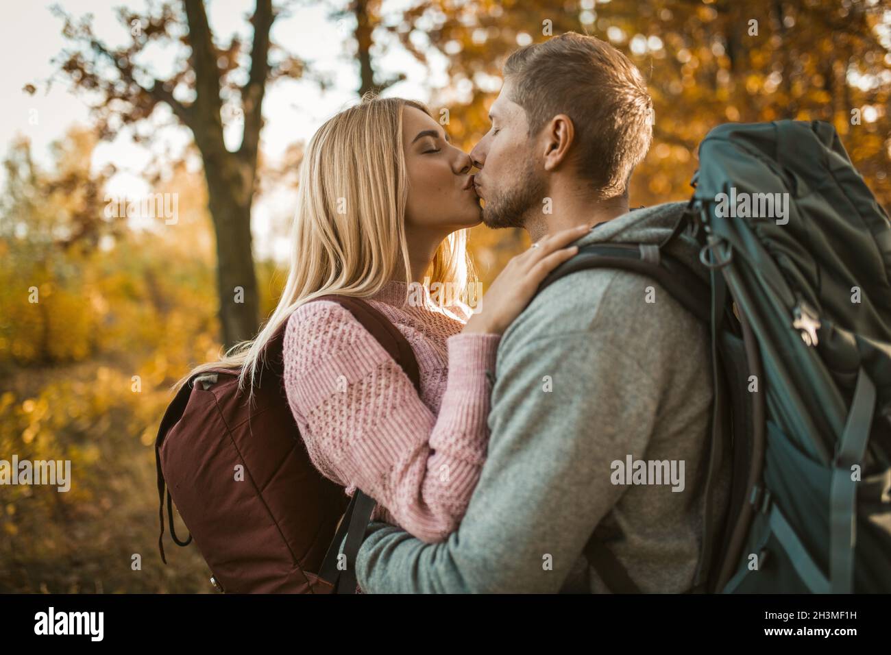 Bacio di giovane coppia nella foresta d'autunno Foto Stock