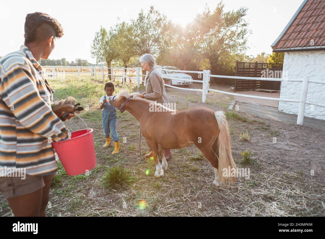 Famiglia multi-generazionale con cavallo in fattoria Foto Stock