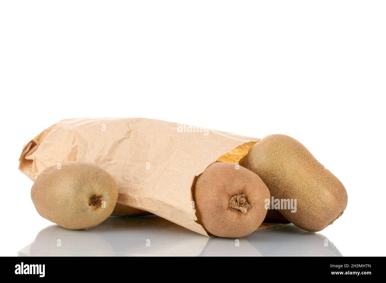 Tre kiwi dolci maturi con sacchetto di carta, primo piano, isolato su bianco. Foto Stock