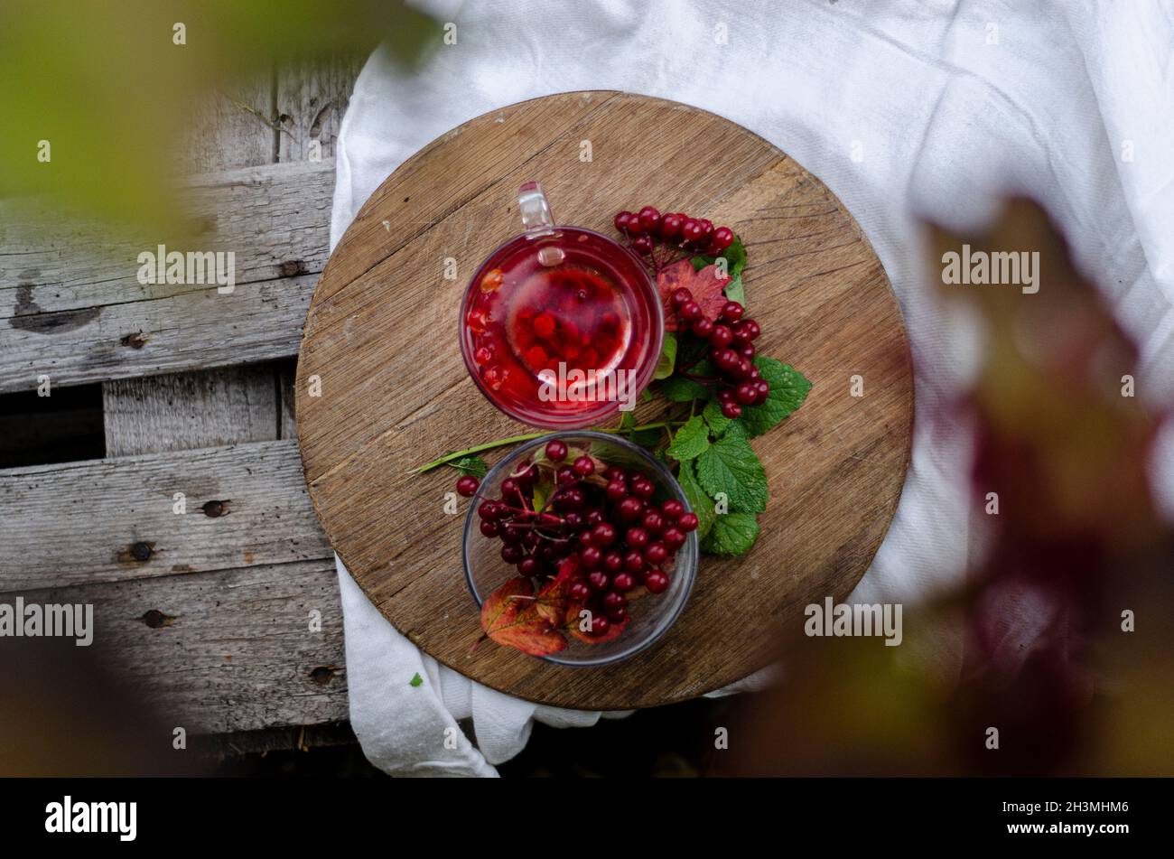 una tazza di tè con viburnum su un asse di legno chiaro tovaglia vista dall'alto Foto Stock