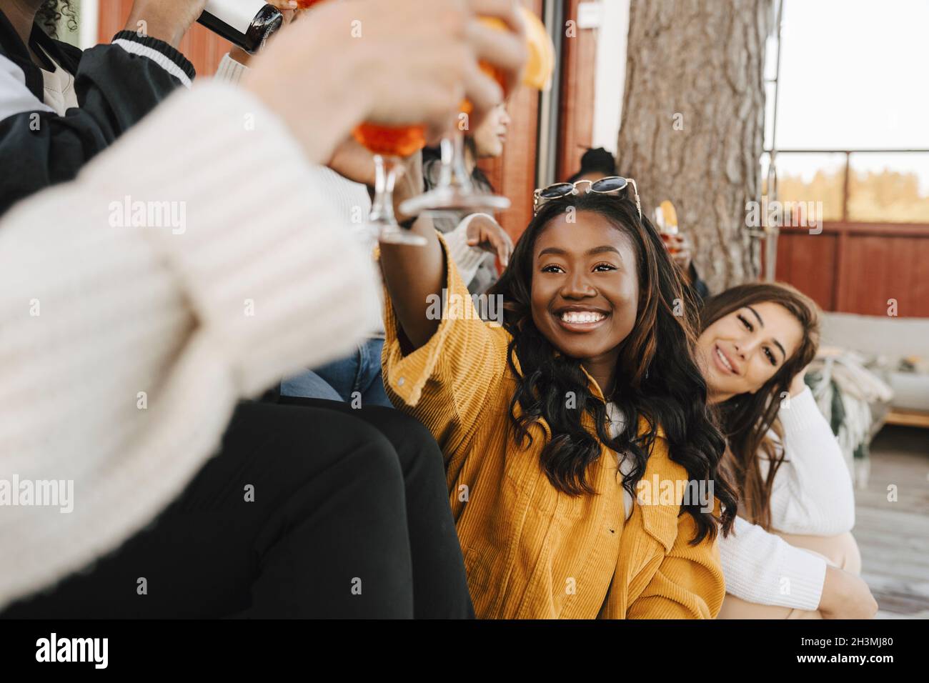 Sorridendo le amiche che bevono bevande durante la festa Foto Stock