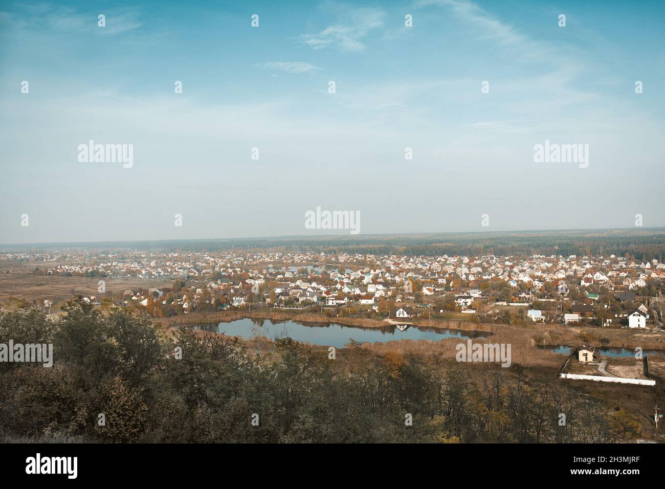 Moderno villaggio cottage o urbano-tipo villaggio sul lago. Paesaggio rurale panoramico contro il cielo blu. Sparato dalla montagna. H Foto Stock