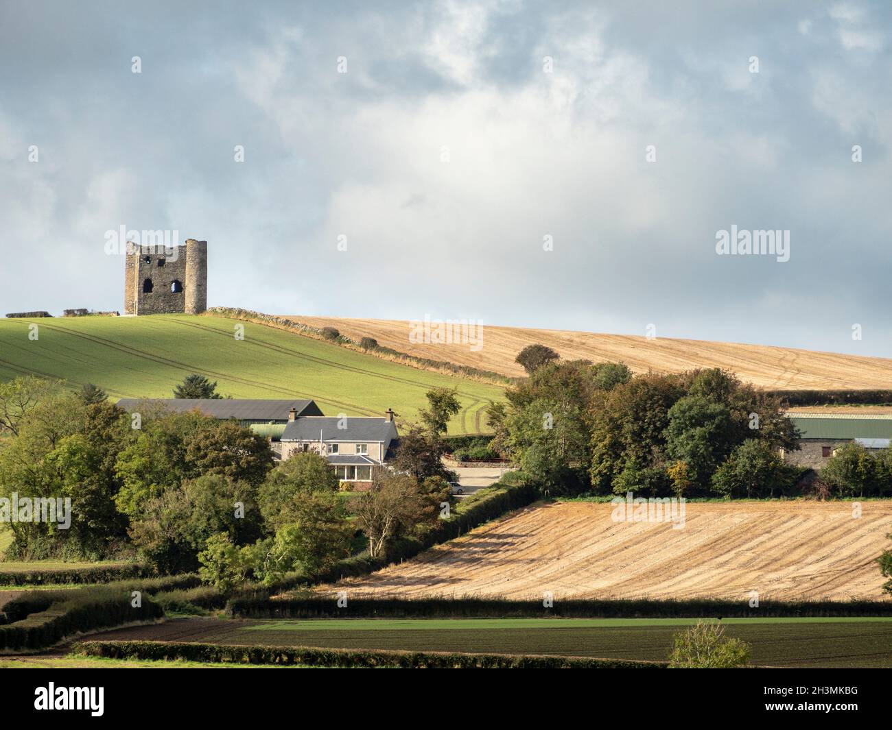 Castello di Burt Donegal: La rovina del Castello di Burt incorona una collina bassa nel paese agricolo di Donegal orientale. Un moderno casale è stato costruito sotto. Foto Stock