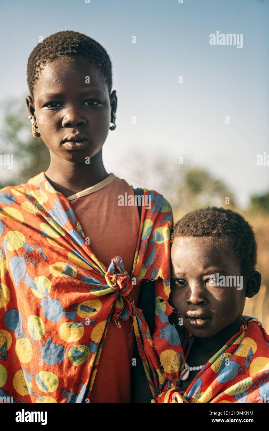 TRIBÙ DI BOYA, SUDAN DEL SUD - 10 MARZO 2020: I bambini di Boya Tribe indossano pezzi di tessuto luminoso e guardano la macchina fotografica mentre s Foto Stock