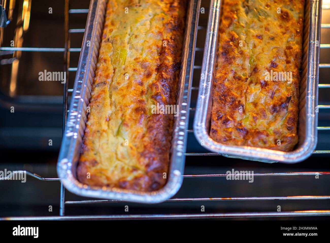 Torta di verdure con peperoni arrostiti in cima. Due stampi quiche nel forno. Cibo sano fatto in casa. Foto di alta qualità Foto Stock