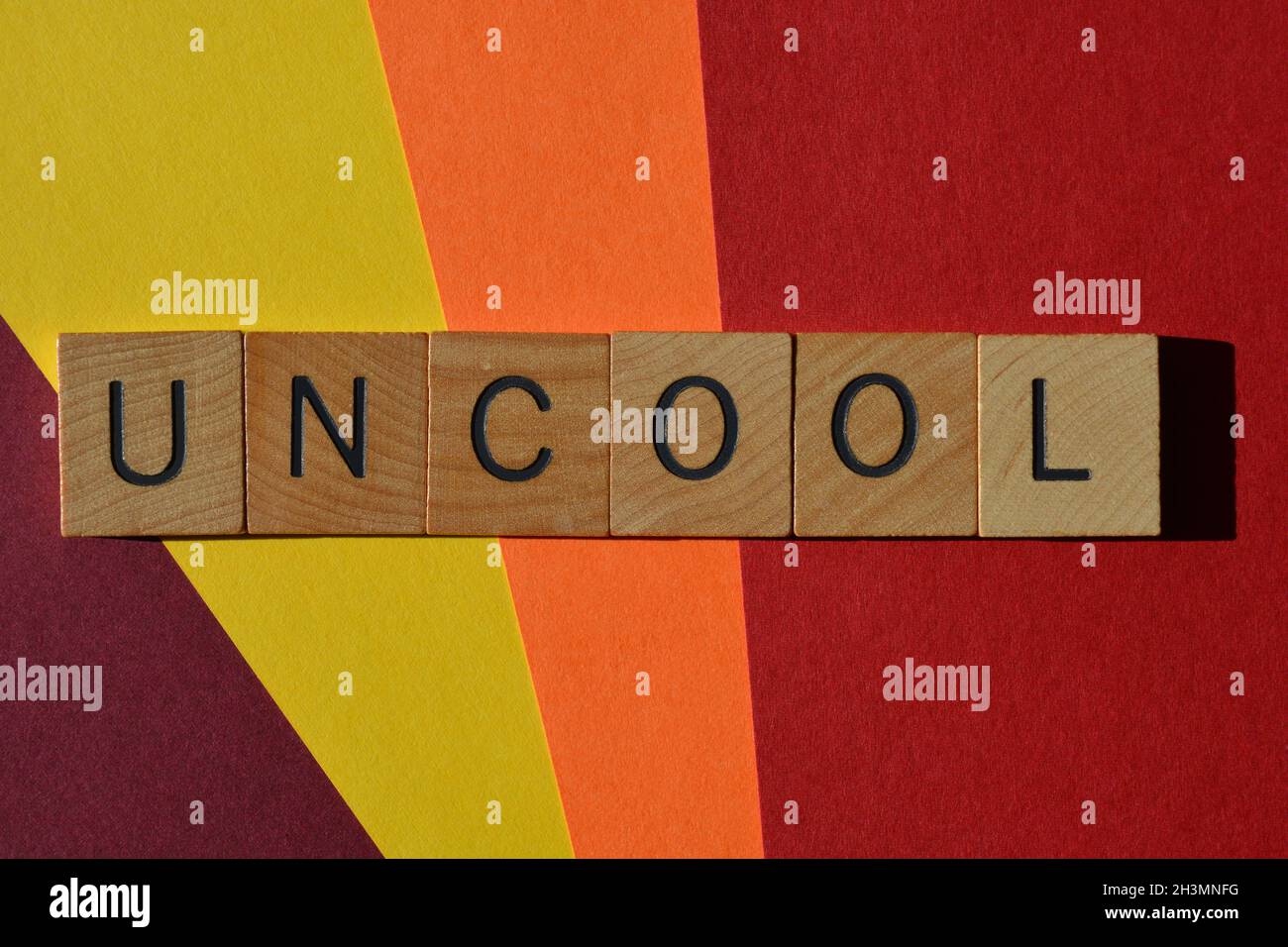 UNCOOL, parola in lettere di legno isolate su sfondo colorato Foto Stock UNCOOL, parola in lettere di legno isolate su sfondo colorato Foto Stock