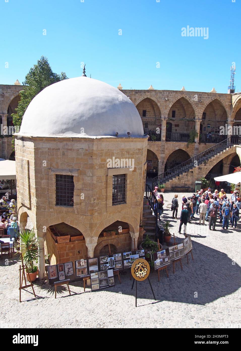 Un gruppo di turisti nel vecchio souk di Nicosia Cipro circondato da negozi e caffè Foto Stock
