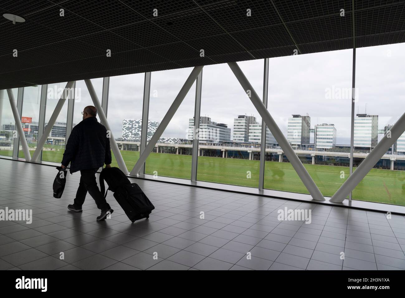 Un passeggero cammina lungo il Concourse B nell'aeroporto di Amsterdam Schiphol, nei Paesi Bassi. Foto Stock