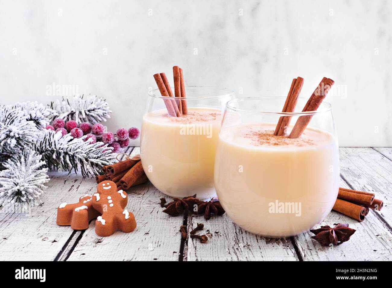 Speziato eggnog di Natale con uomini di pan di zenzero e decorazioni per le vacanze su sfondo bianco Foto Stock