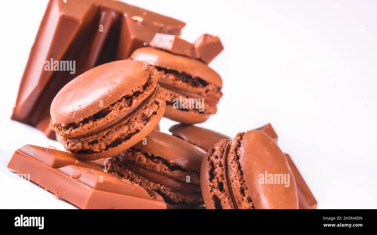 Macaroon con cioccolato dolce e fagioli di caffè su tavola bianca di legno. Foto di alta qualità Foto Stock