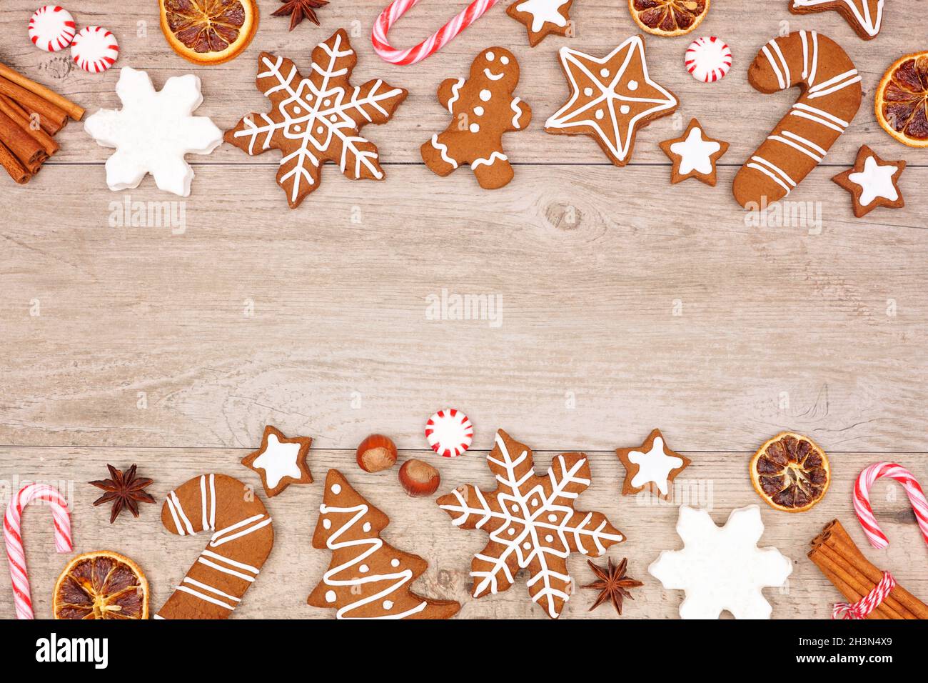 Biscotti di pan di zenzero di Natale, caramelle e prodotti da forno. Vista dall'alto bordo doppio su sfondo di legno. Foto Stock