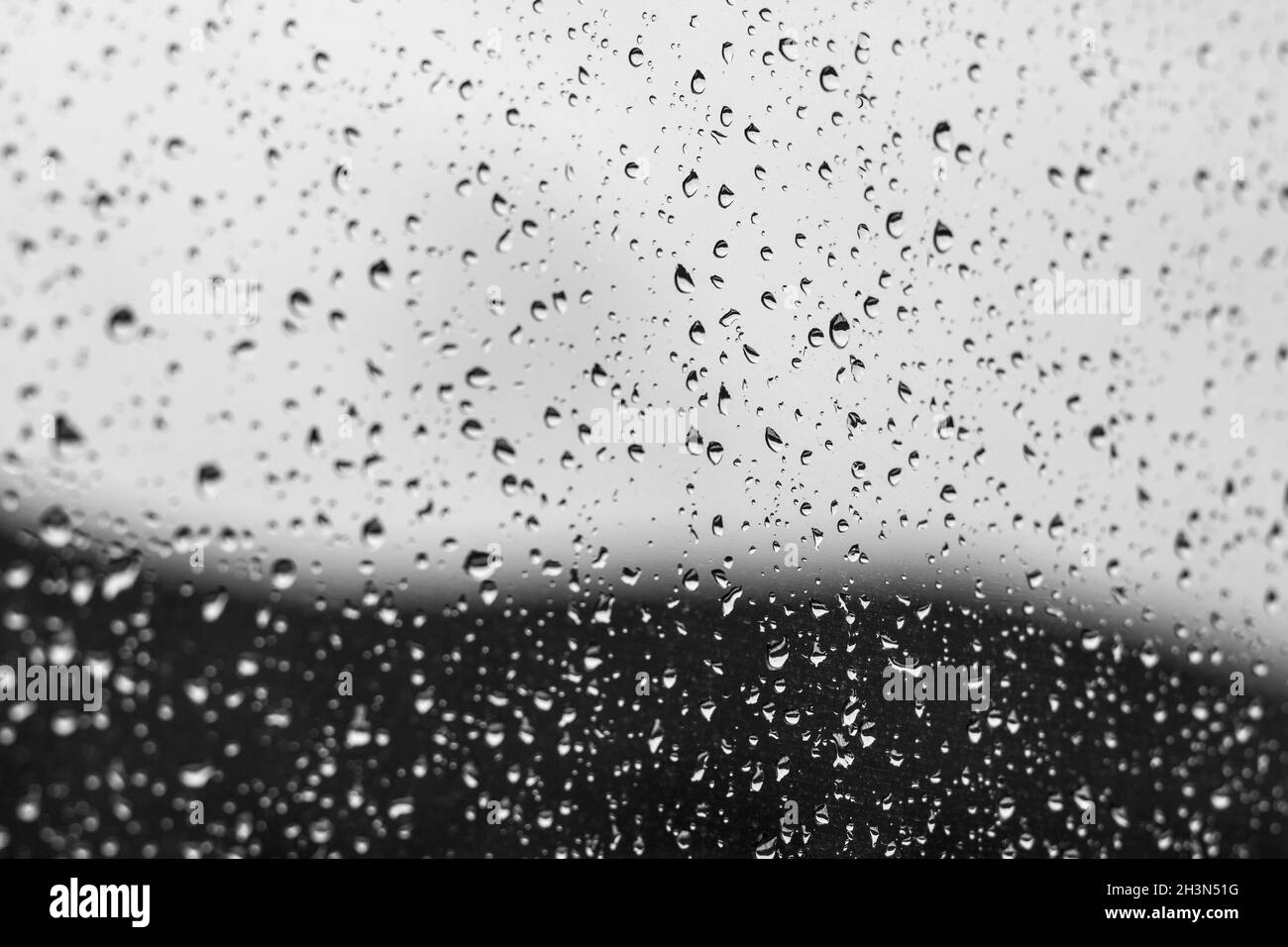 Gocce d'acqua sul vetro con montagna sfocata sullo sfondo. Concetto di pioggia Foto Stock