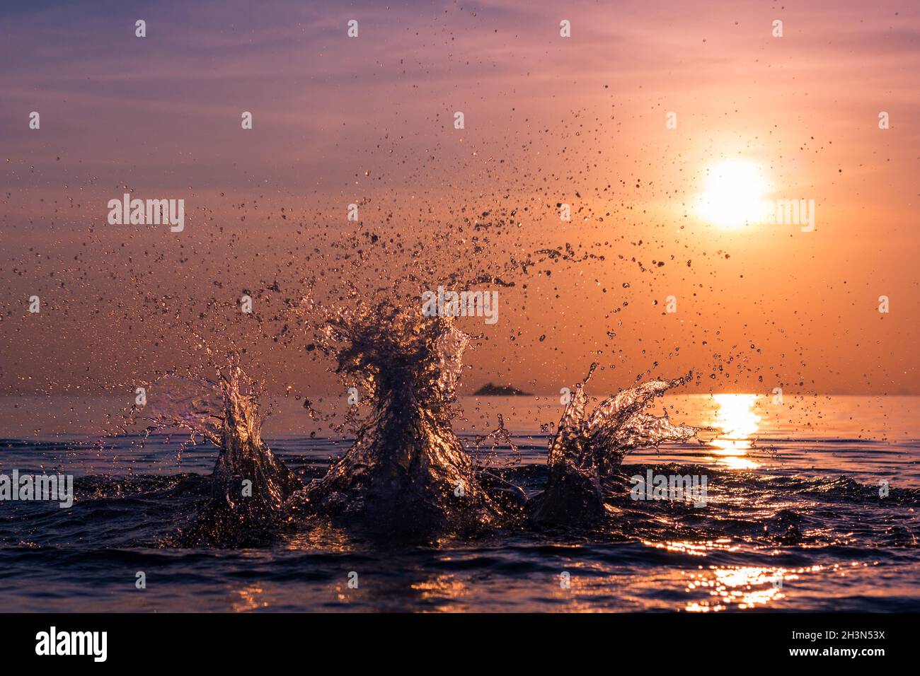 Spruzzi di gelo d'acqua in movimento allo splendido tramonto colorato sulla spiaggia nell'isola di Koh Phangan, Thailandia. Fresco e fresco al crepuscolo Foto Stock