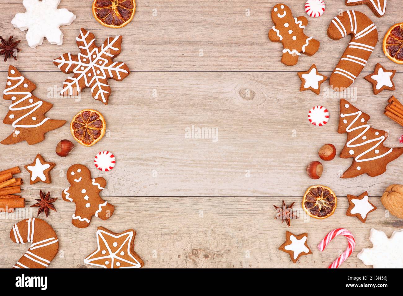 Biscotti di pan di zenzero di Natale, caramelle e prodotti da forno. Vista dall'alto bordo laterale doppio su sfondo di legno con spazio di copia. Foto Stock