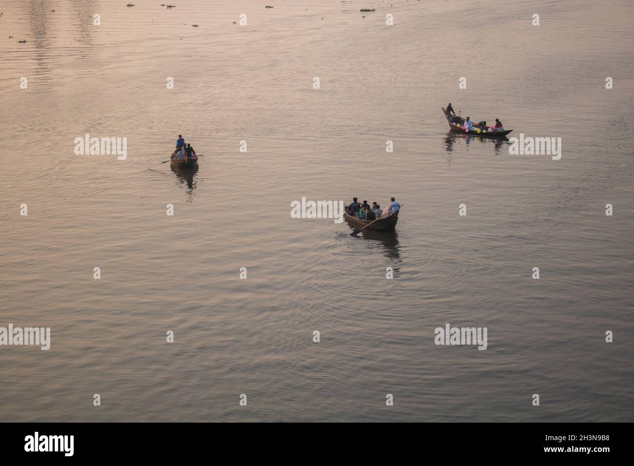 La barca galleggia nella luce dorata del pomeriggio. Questa è una vista del fiume Buriganga in Bangladesh. Foto Stock