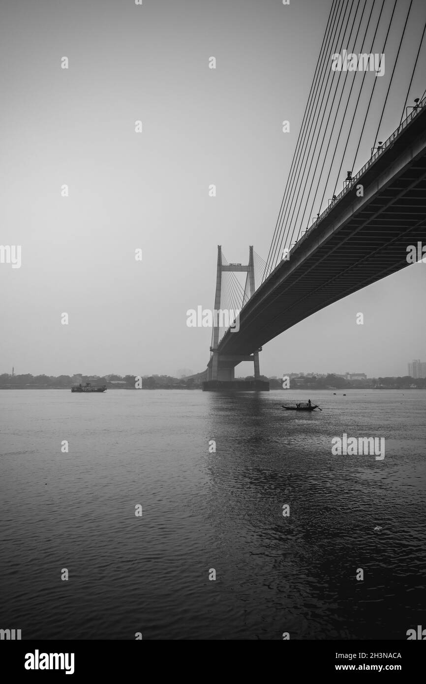 Colpo verticale di un ponte James Prinsep Ghat in scala di grigi a Kolkata, India Foto Stock