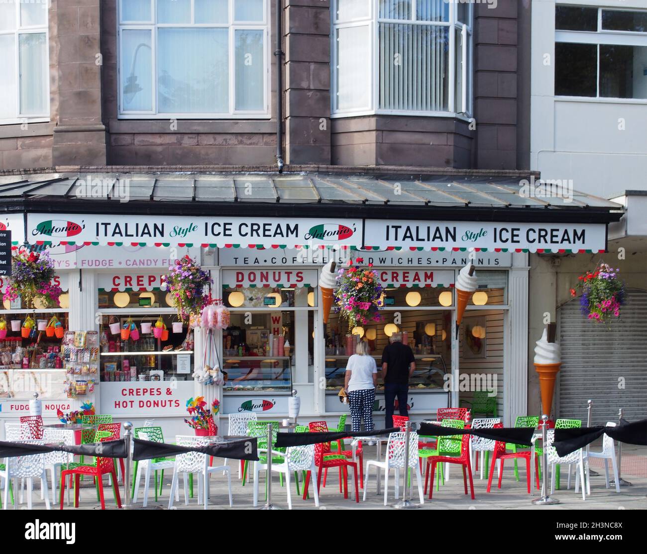 Persone che acquistano gelato al negozio Antonios e caffè a Southport Merseyside Foto Stock