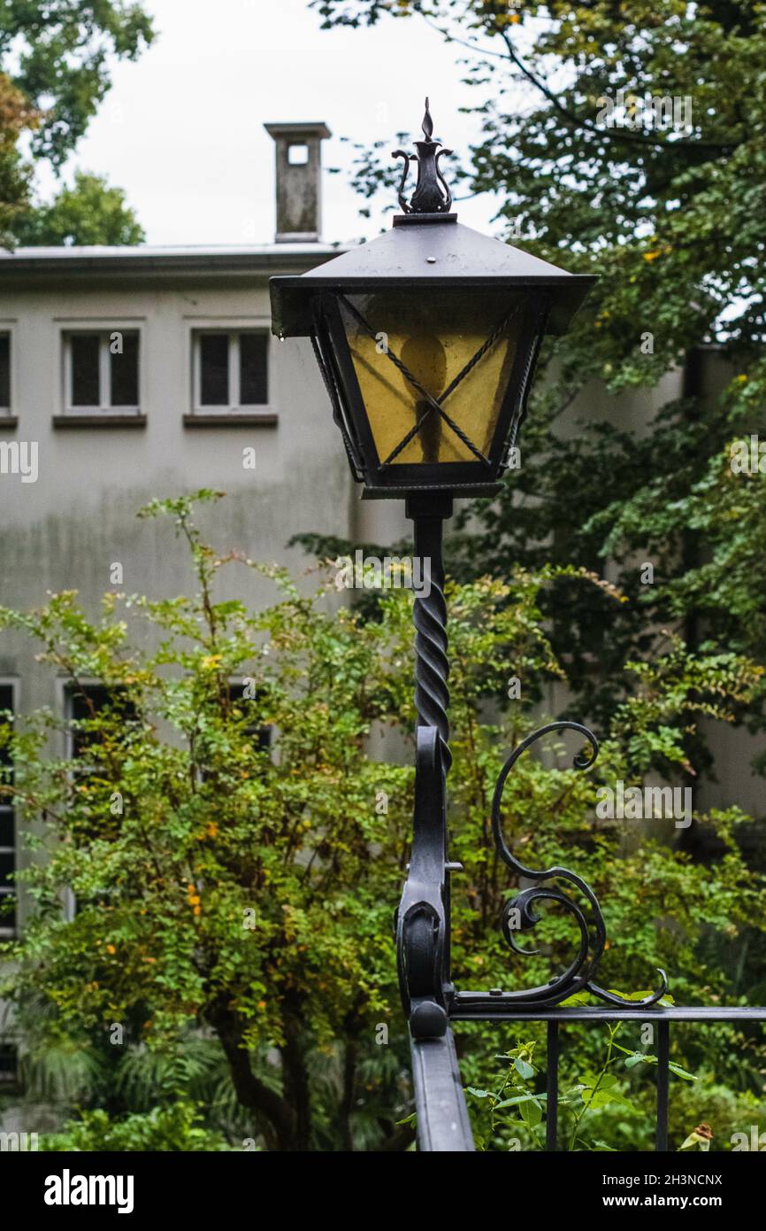 Scatto verticale di un palo di luce in giardino e di un edificio sullo sfondo Foto Stock