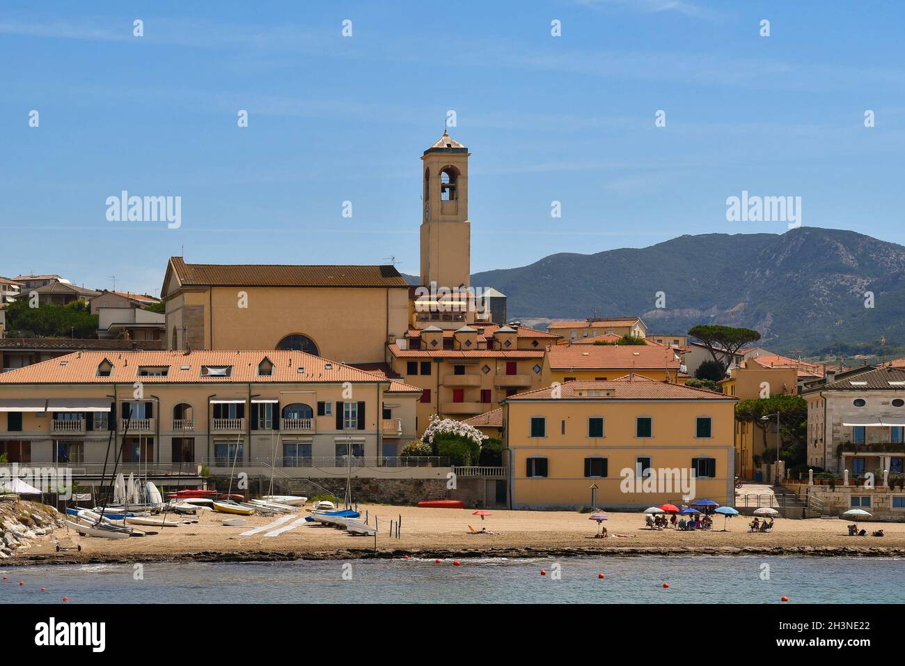 Vista sul villaggio di pescatori sulla costa toscana con la spiaggia sabbiosa e la chiesa principale in estate, San Vincenzo, Livorno, Toscana, Italia Foto Stock